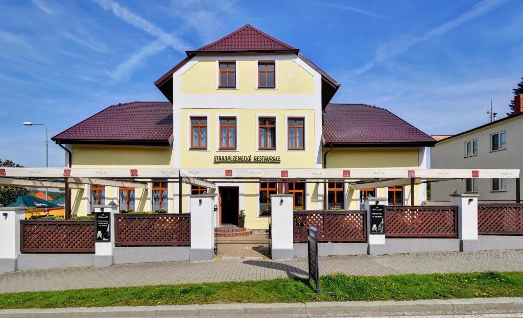 a large yellow building with a red roof at Penzion pod Radyni in Starý Plzenec