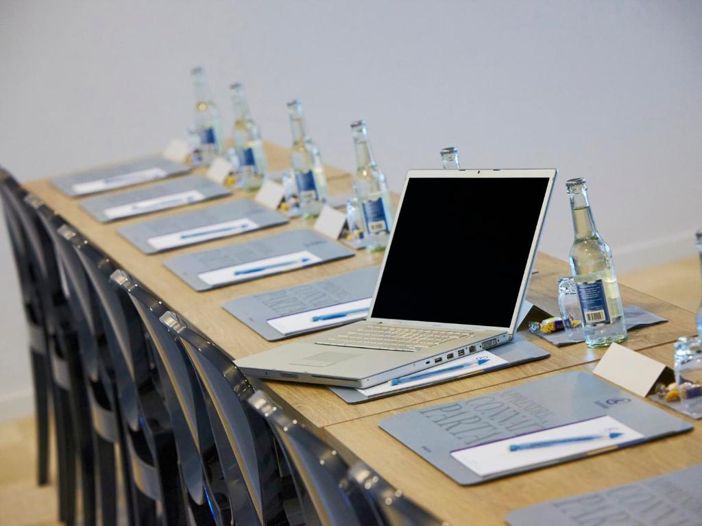a long table with a laptop computer on top of it at Kyriad Prestige Residence & Spa Cabourg-Dives-sur-Mer in Dives-sur-Mer