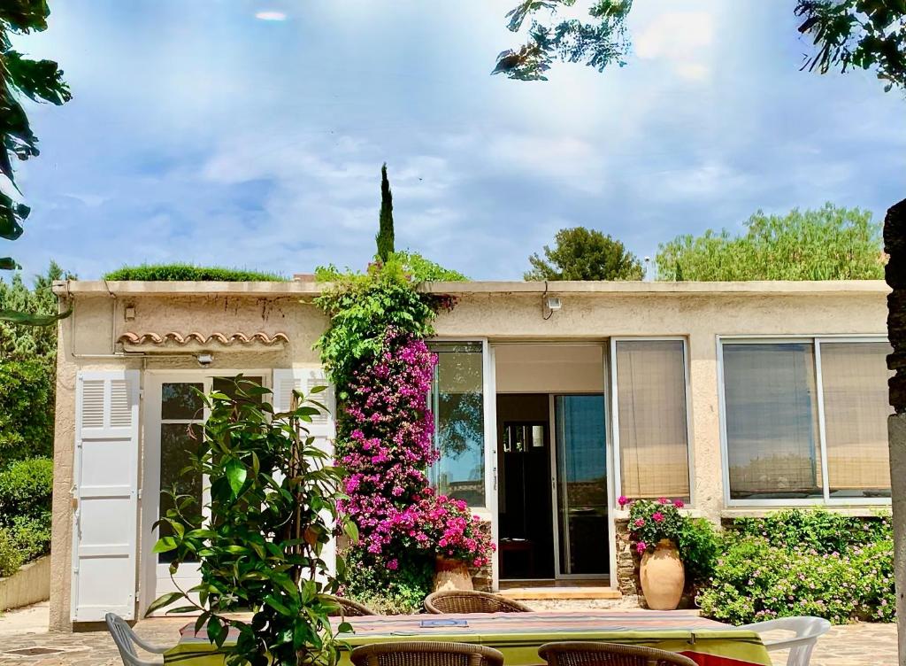a house with flowers and a table in front of it at Villa de la brune in Bormes-les-Mimosas