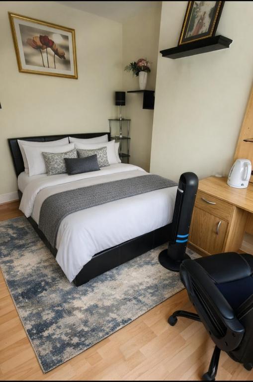 a bedroom with a bed and a desk and a chair at Bliss Home in Harrow on the Hill