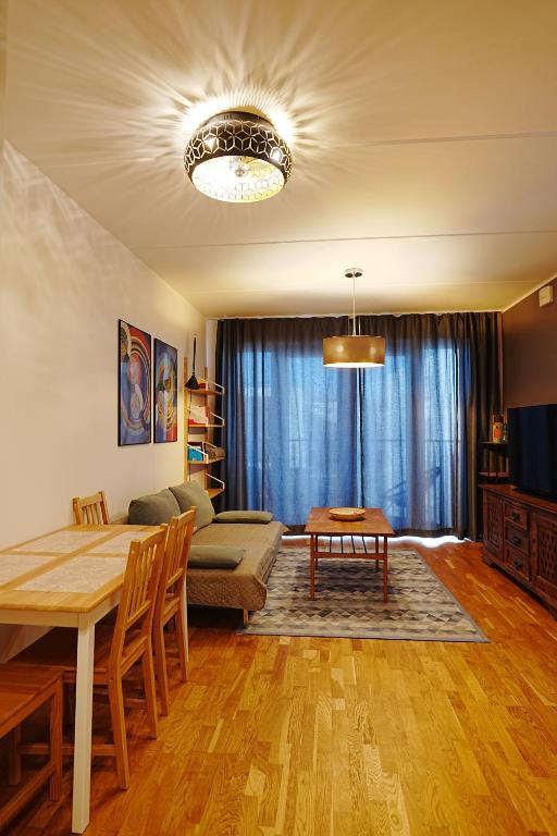 a living room with a table and a couch at Modern apartement with a balcony in Tallinn