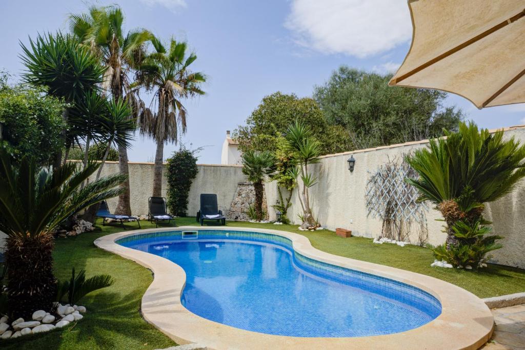 a swimming pool in a yard with palm trees at Capavila by Rentallorca in Muro