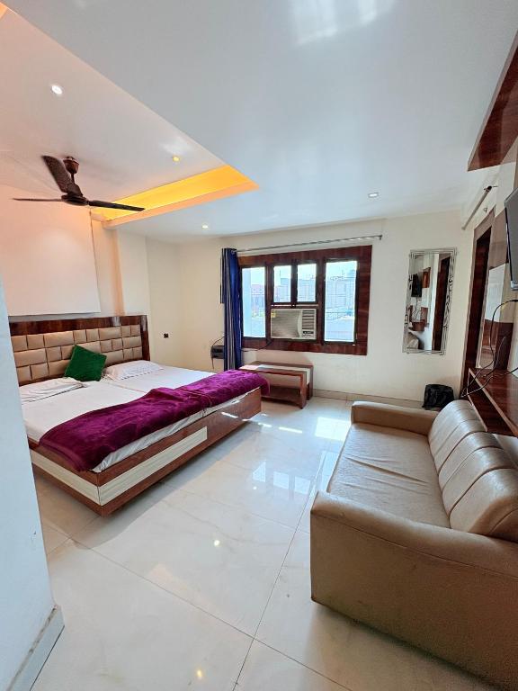 a bedroom with a large bed and a couch at Kartar Yatri Niwas in Kānpur