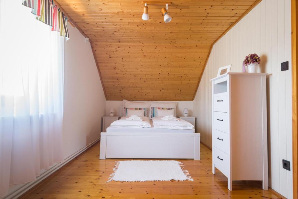 a bedroom with a bed and a wooden ceiling at BorászPorta in Villány