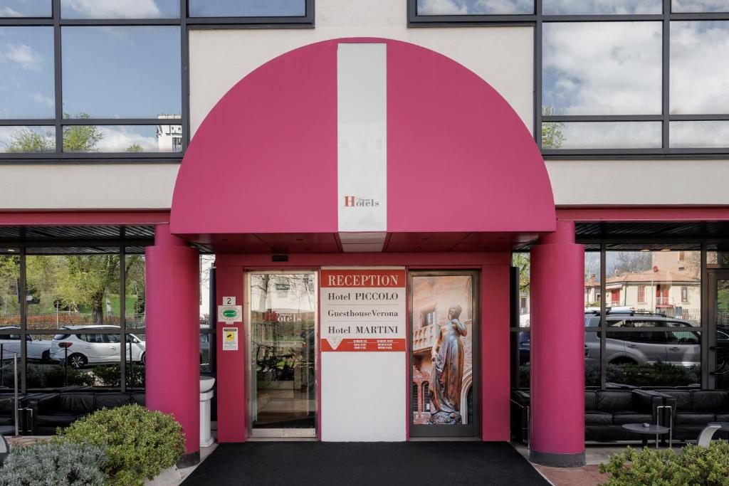 a pink building with a sign in the doorway at Hotel Martini in Verona