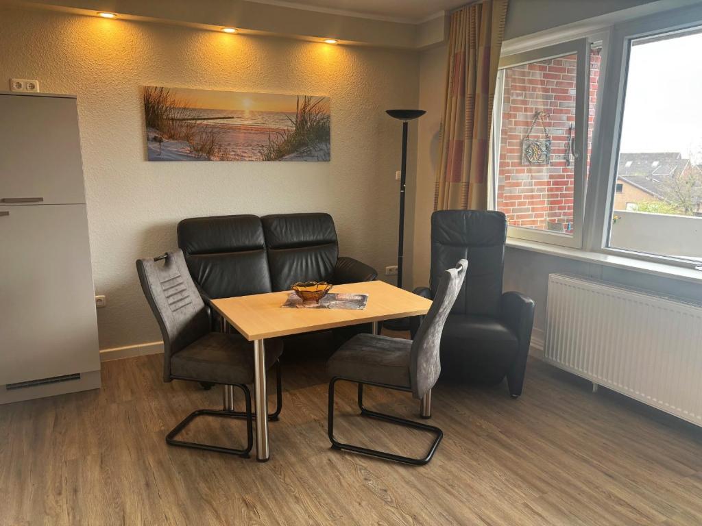 a waiting room with a table and chairs at Tief 10 Wattwurm in Wangerland