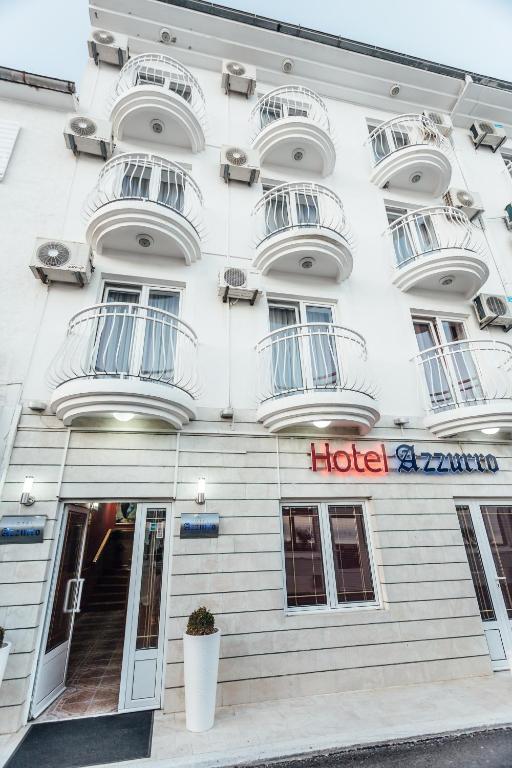 ein weißes Gebäude mit einem Hotelschild darauf in der Unterkunft Hotel Azzurro in Herceg-Novi