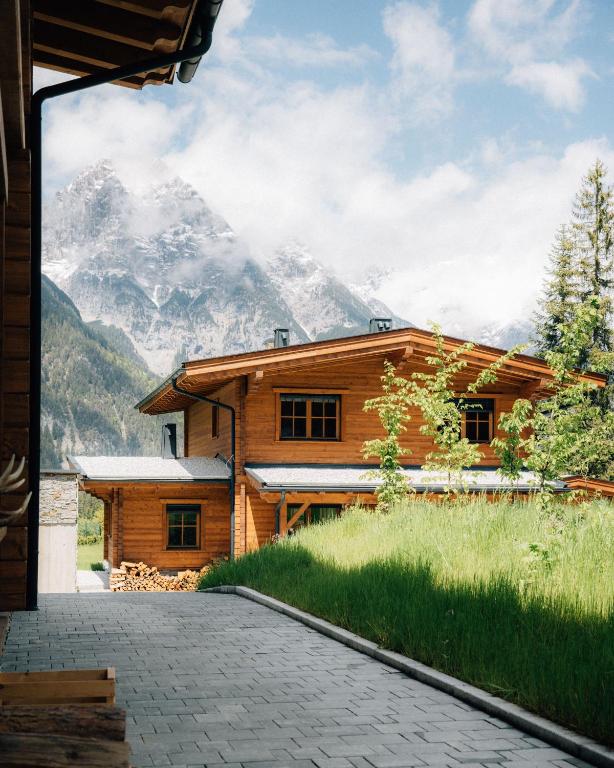 a log house with a mountain in the background at Sissi green Chalets in Seefeld in Tirol