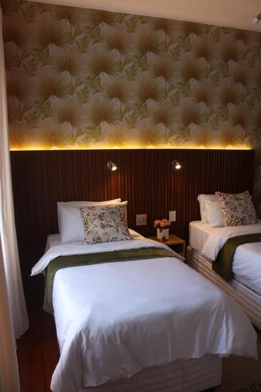 two beds in a room with lights on the wall at Townside Estate Room number 10 in Ladysmith