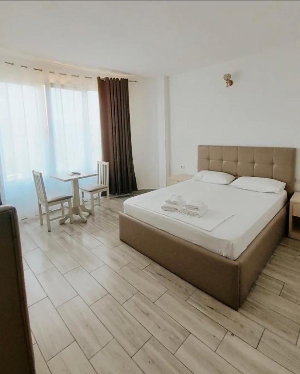 a bedroom with a large bed and a table at Hotel Restaurant Univers Shiroke in Shirokë