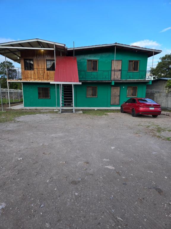 a green building with a red car parked in front at Affordable Spacious Studio Apartment in Nueva California