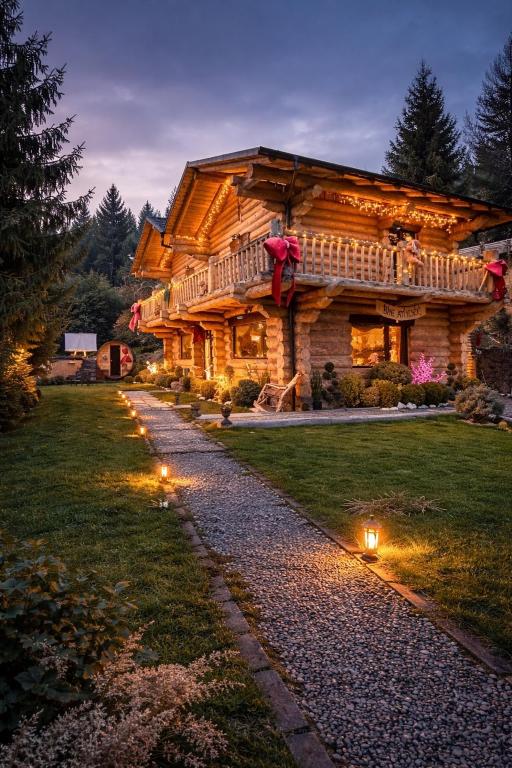 a log cabin with lights in front of it at The Mountain's Sea Chalet in Colibiţa
