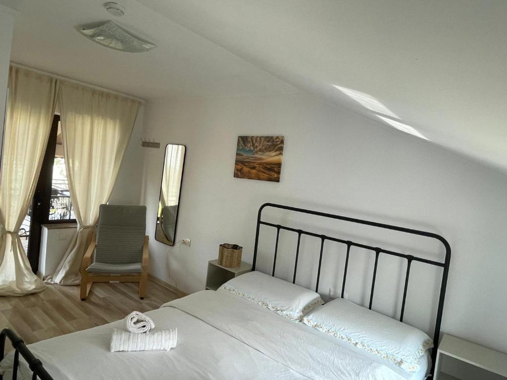 a white bedroom with a bed and a chair at Casa Haralambie in Greci