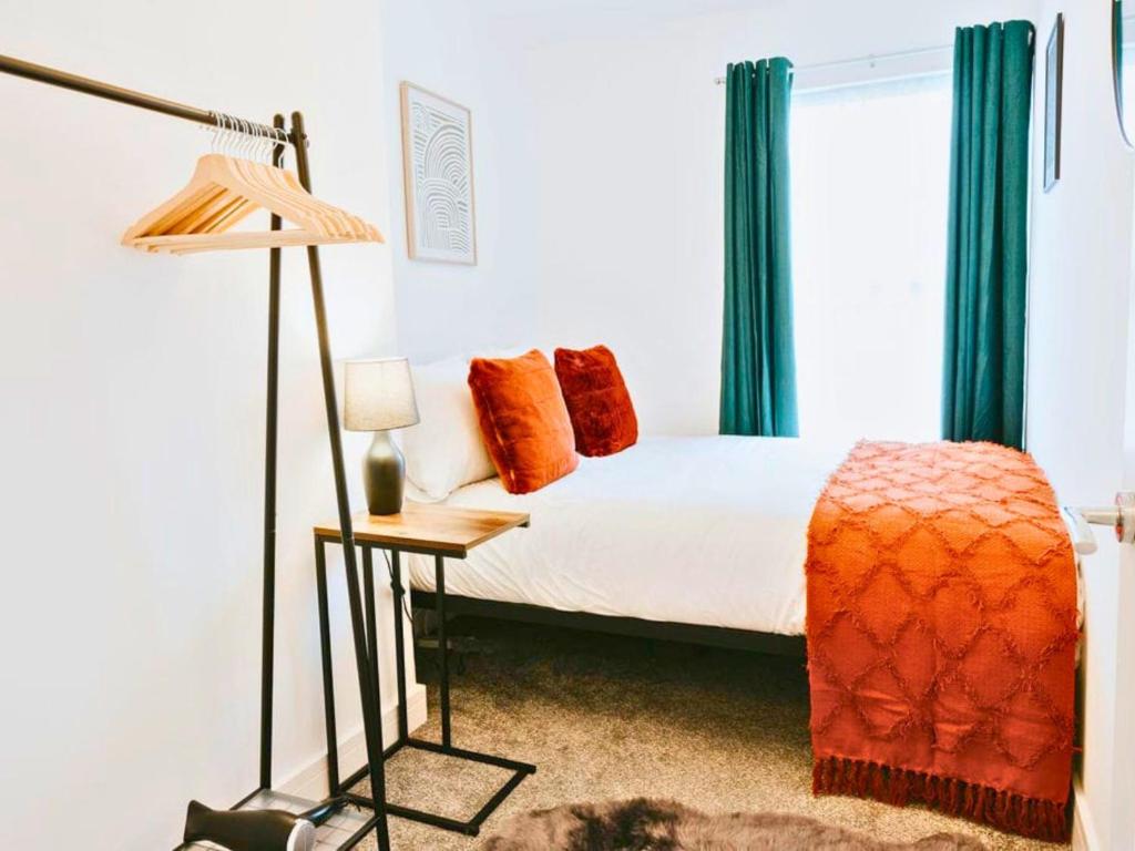 a bedroom with a bed and a window with green curtains at St Helens 3BR Home with Garden, Fast WiFi, Smart TV, Sleeps 6, Contractors & Long Stay Accommodation in Saint Helens