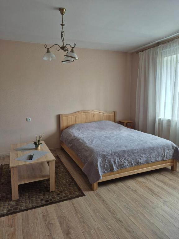 a bedroom with a bed and a table at Sunrise in Rēzekne