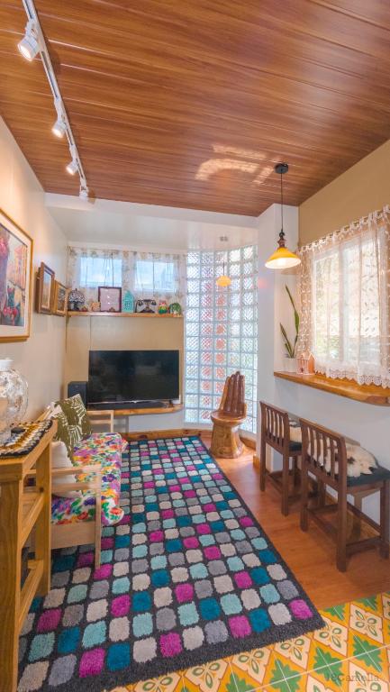 a living room with a television and a large rug at 18 Camella in Baguio