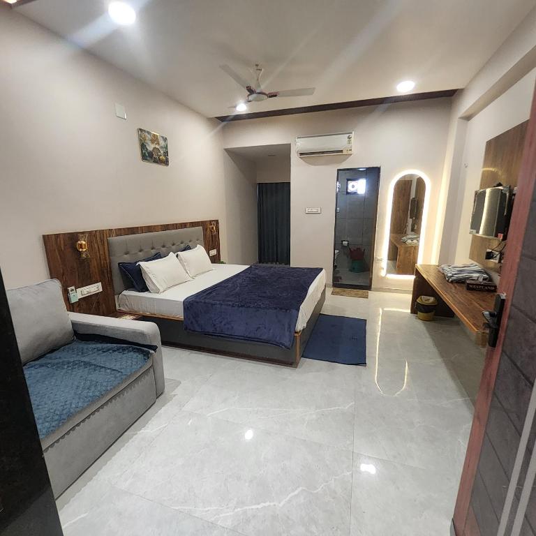 a bedroom with a bed and a couch in it at Hotel Anmol&Rooms in Gothaj
