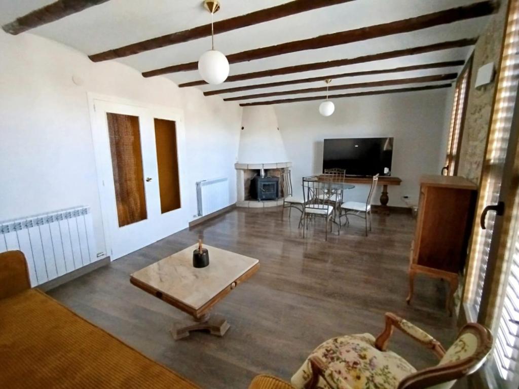 a living room with a couch and a table at Cozy rural apartment in Calaceite
