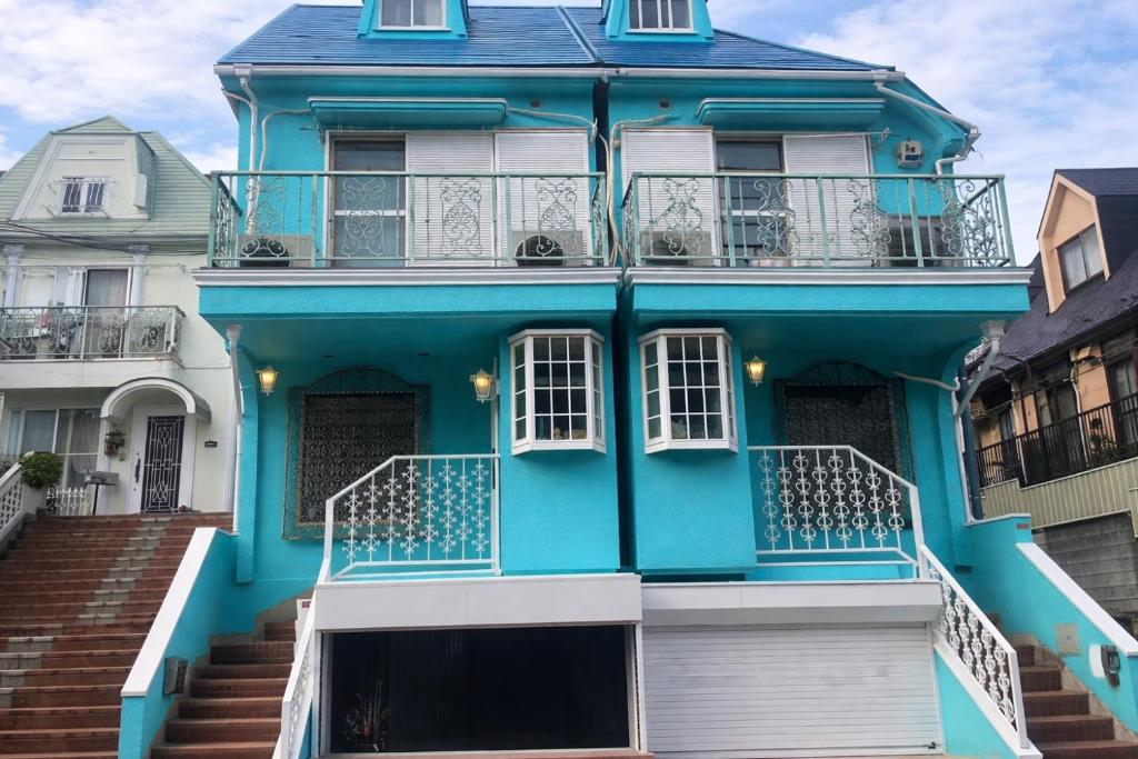 a blue house with stairs in front of it at Alia House 旅館 in Tokyo