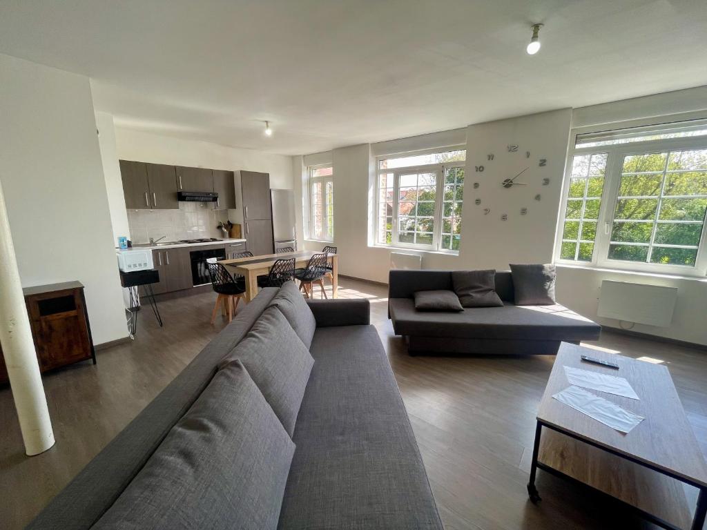 a living room with a couch and a table at Business Apparts Caudry in Caudry