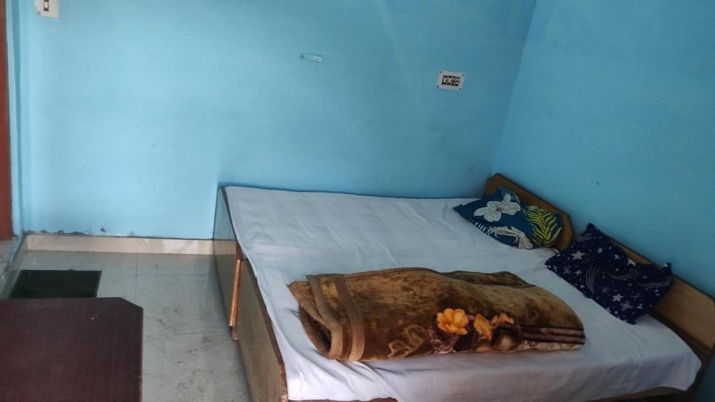 a bed with a blanket on it in a room at Kedar Kunj in Phata