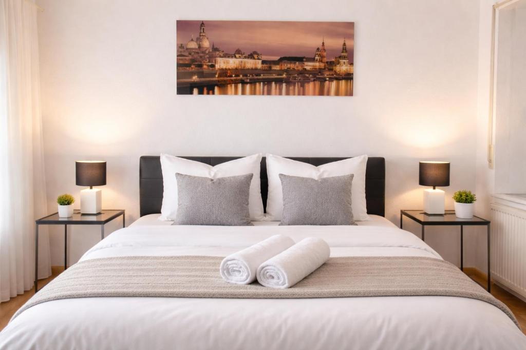a bedroom with a large white bed with two lamps at Comfortable Apartment on Elbe River in Dresden