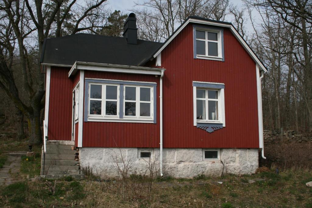 a red and white house with white windows at Gyllene tranans hus in Gammalstorp