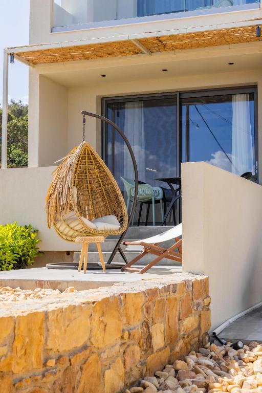a rattan chair sitting on the front porch of a house at Enalis Studios & Apartments in Karfas