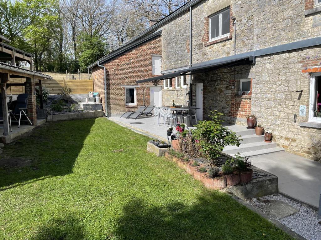 a backyard of a brick building with a grass yard at Gite Au Fil du Temps in Walcourt