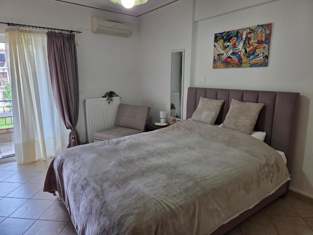 a bedroom with a large bed and a chair at Lena's Nest Nafpaktos in Nafpaktos