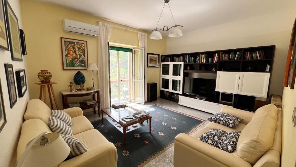 a living room with two couches and a tv at WELCOME - Scilla Casa Vacanze in Scilla