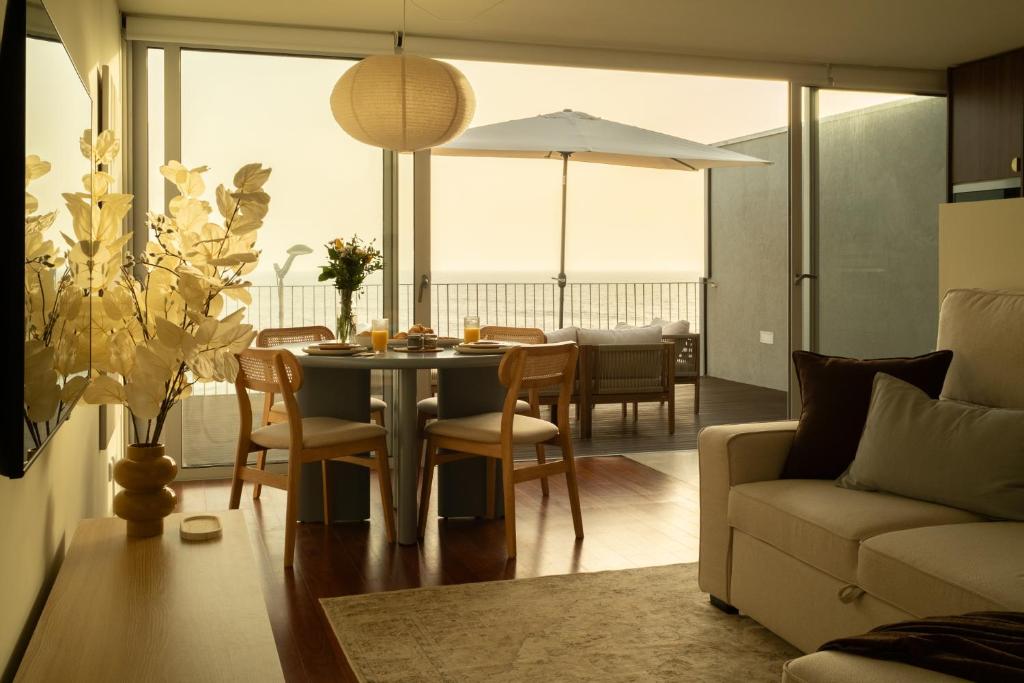 a dining room with a table and chairs and a couch at Casanova Seaside in Porto