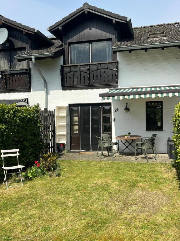 a house with a table and chairs in the yard at Ferienwohnung mit Garten am Venekotensee in Niederkrüchten