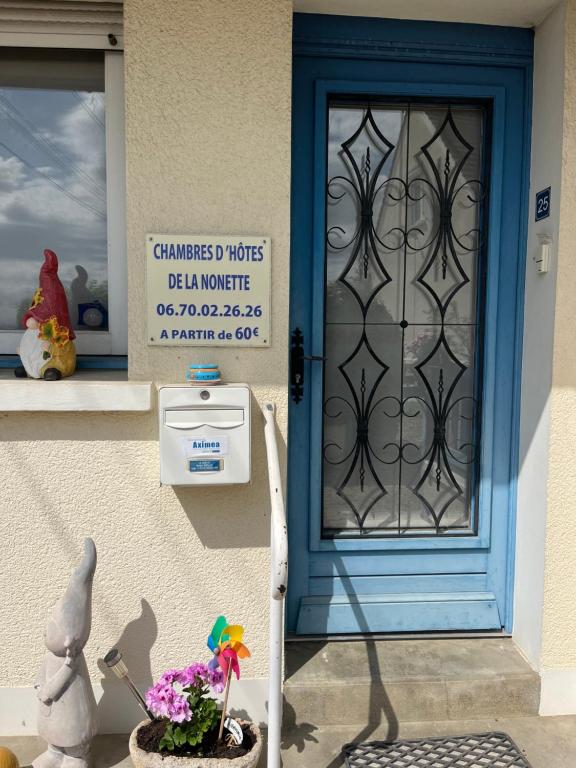 a blue door with a sign on the side of a house at chambres de la Nonette in Senlis