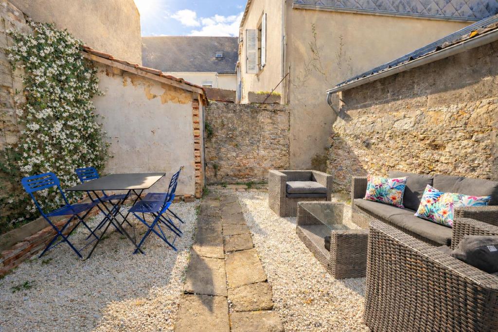 a small patio with a table and chairs and a couch at Maison du Caboteur de La Baule, Centre & plage à pied, Patio cosy, 8 pers in Le Pouliguen