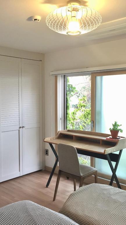 a room with a table and a chair and a window at Summer's House in Jeju