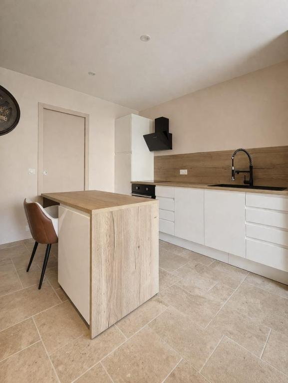 a kitchen with white cabinets and a sink and a counter at Studio Spa Murol Centre Relaxation in Murol