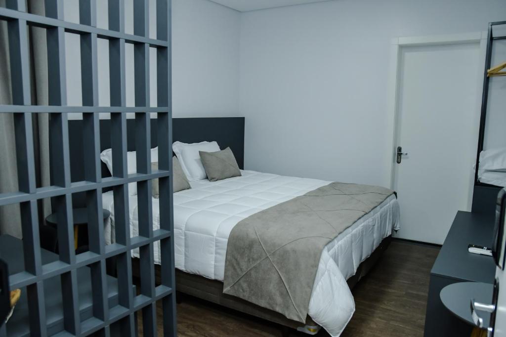 ein Schlafzimmer mit einem Bett mit weißer Bettwäsche in der Unterkunft Caza Flat Hotel in Constantina