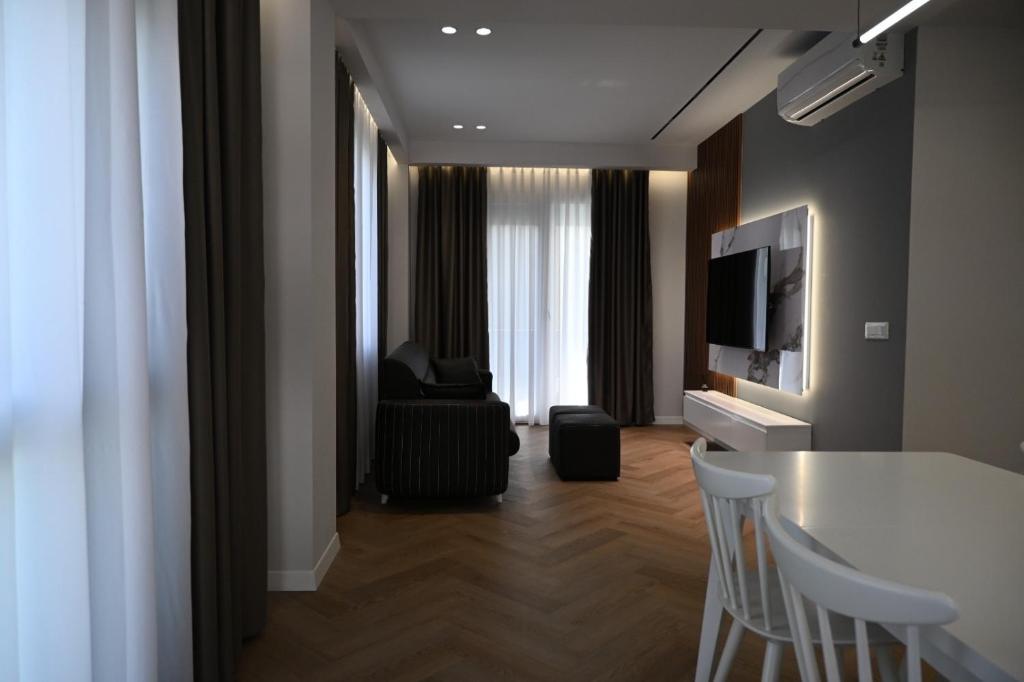 a living room with a table and chairs and a television at Villa Billa in Tirana