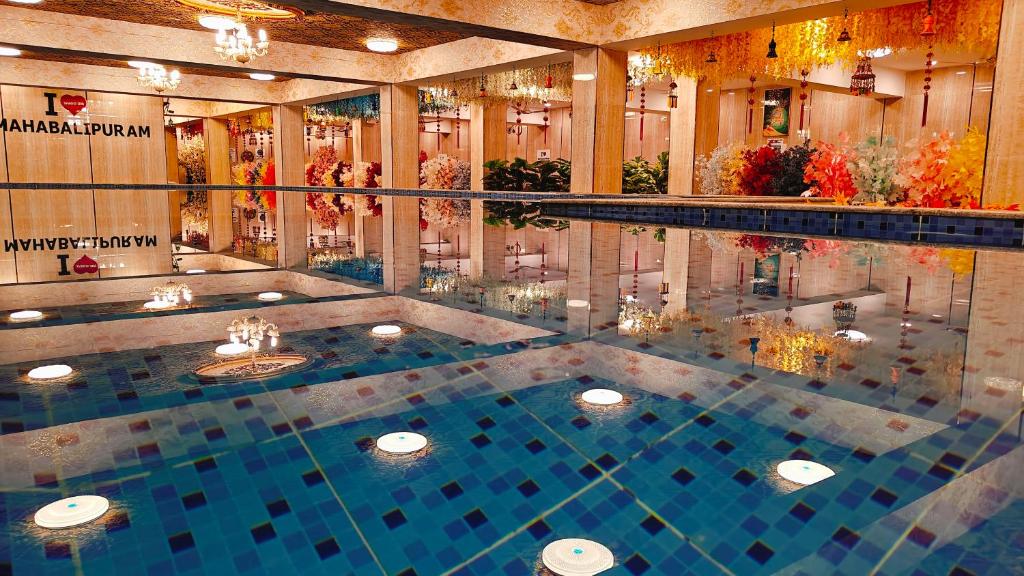 a large swimming pool in a building with a pool at Spago Inn-Only for Families & Couples not for Bachelors in Mahabalipuram