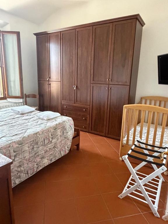 a bedroom with a bed and a cabinet and a chair at Molinella Appartamento Amelia & Carlo in Molinella