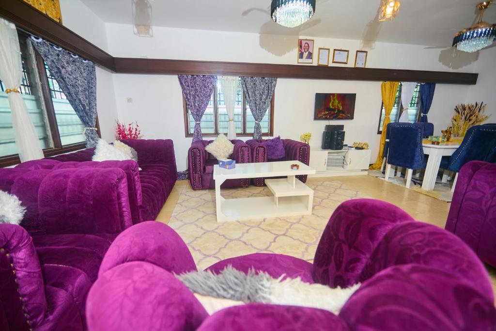 a living room with purple chairs and purple couches at Cutie 3 br Villa Nyali in Mombasa