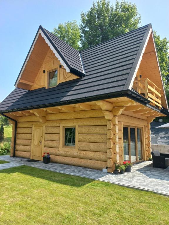a log cabin with a black roof at Potokowe Zacisze in Zakopane