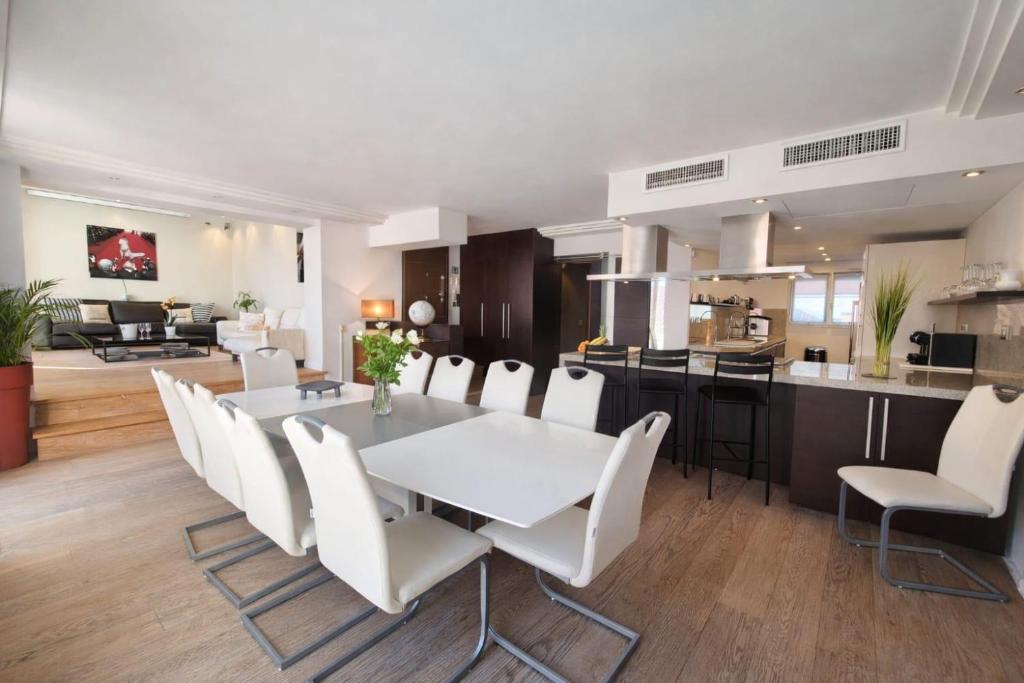 a dining room and kitchen with a white table and chairs at Suite Notre Dame - Appartements in Cannes