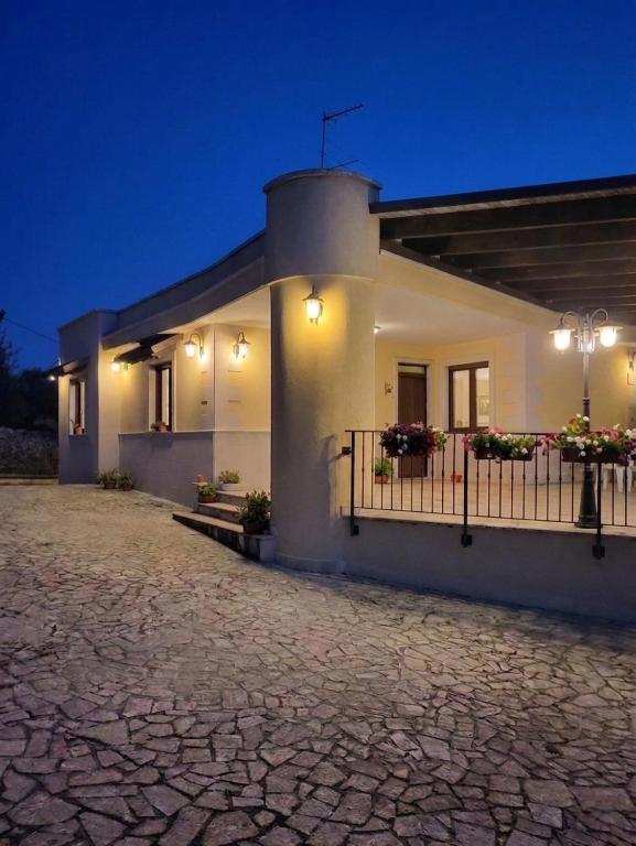 a white house with a balcony at night at Villa Colline Fiorite in Putignano