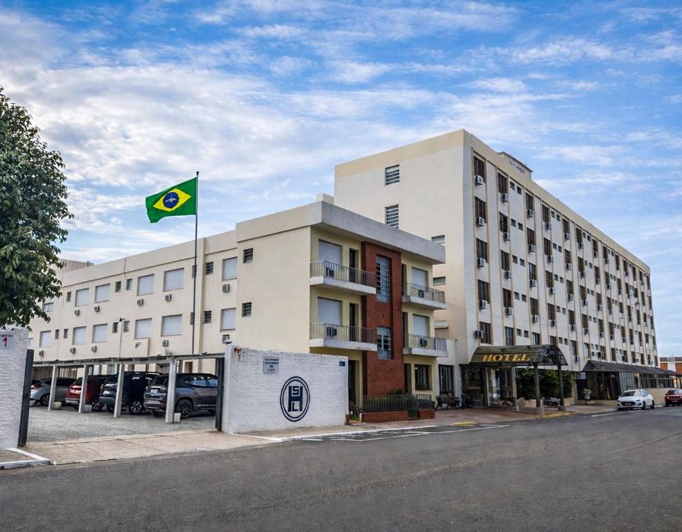 a building with a green flag in front of it at Hotel São Luiz in São Gabriel
