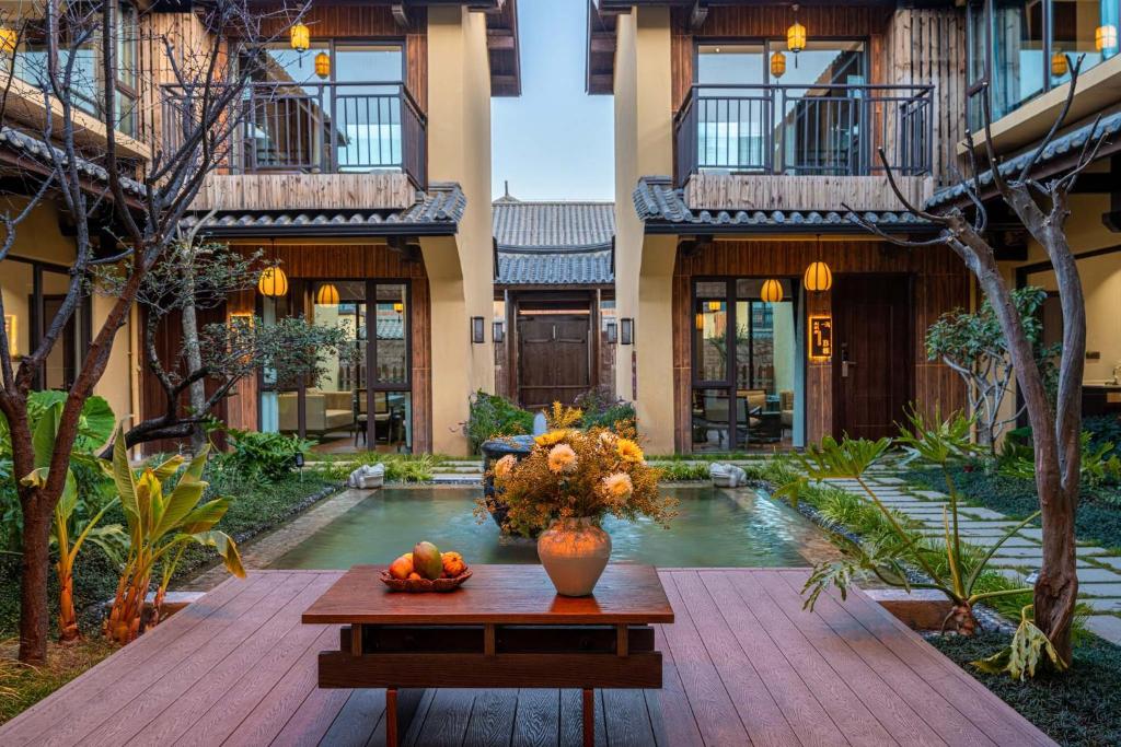 a courtyard of a building with a table with fruit on it at Aofeng Tangquan Secluded Villa in Jianchuan