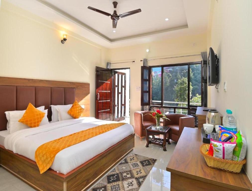 a bedroom with a large bed and a living room at LA Riqueza Dhanolti View - View of Valleys & Mountains - Private Parking - Near to Eco Park & Surkanda Devi Temple in Dhanaulti