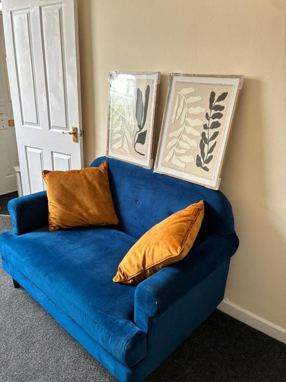 a blue couch with two pillows in a room at Cute Central House Sleeps 4 in Stafford