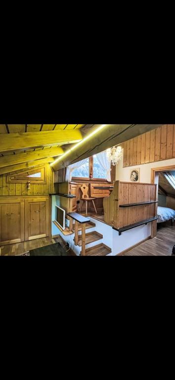 a large room with a kitchen with a table at Bilocale con vista sui monti in Pinzolo